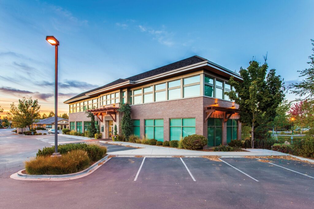 A modern two-story office building in Eagle, ID, captured at sunset with a clear blue sky.